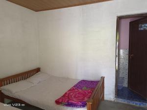 蒙纳Munnar Home Stay的一间卧室配有一张床铺,床上铺有紫色毯子
