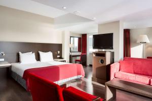 阿纳姆阿纳姆莱克NH酒店的酒店客房,配有一张床和一张红色的沙发
