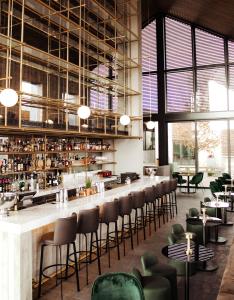 帕福斯Minthis Resort的餐厅设有酒吧,配有桌椅