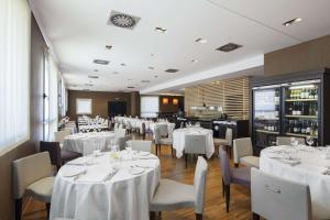 罗镇米兰国际会展中心NH酒店的用餐室配有白色的桌子和白色的椅子