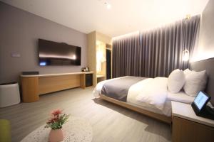 釜山Hound Hotel Junggwan的配有一张床和一台平面电视的酒店客房