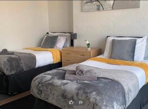 雷德卡Tudor Lodge - Redcar Beach的一间卧室配有两张带毛巾的床