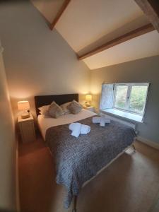 阿尔斯通Clifton Cottage at Lovelady Shield的一间卧室设有一张大床和一个窗户。