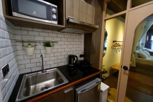 曼谷Krung Boutique Hotel的一间带水槽和微波炉的小厨房