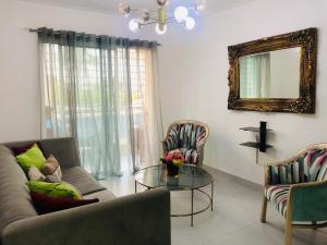 圣地亚哥洛斯卡巴Oasis Palma Real santiago, Republica Dominicana的带沙发和玻璃桌的客厅