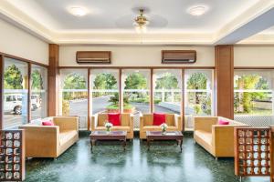 甘德希罕Holiday Resort & Spa A Unit of S Poddar Group的带沙发和桌子的客厅以及窗户。