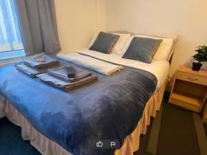 雷德卡Tudor Lodge - Redcar Beach的一间卧室配有一张大床和毛巾