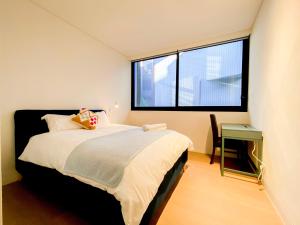 悉尼Pyrmont Town House Homestay的一间卧室设有一张床和一个大窗户
