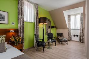 克勒伊斯贝尔亨Hotel De Pupiter的一间卧室设有绿色的墙壁和一张床及椅子