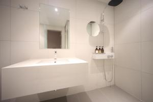 釜山Hound Hotel Junggwan的白色的浴室设有水槽和镜子