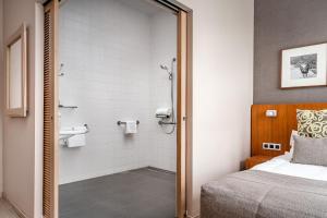 克勒伊斯贝尔亨Hotel De Pupiter的一间卧室配有一张床,浴室设有淋浴。
