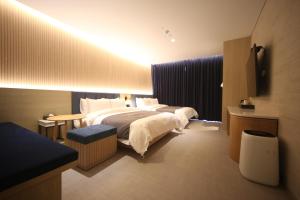 釜山Hound Hotel Junggwan的酒店客房设有两张床和电视。