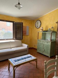 奥罗塞伊Orosei RE - Villa Samuela a 50 m dal mare的客厅配有沙发和墙上的时钟