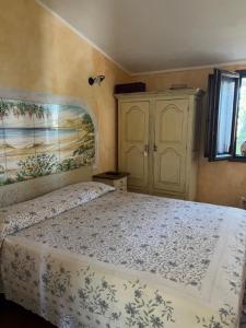 奥罗塞伊Orosei RE - Villa Samuela a 50 m dal mare的卧室配有一张床,墙上挂有绘画作品