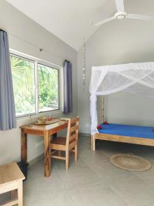米查维Princess of Zanzibar的一间卧室配有书桌、一张床和一张桌子