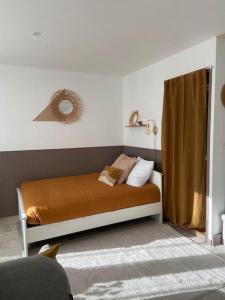 布雷斯地区布尔格Studio avec Balcon proche Gare的一间卧室配有带橙色床单和枕头的床。