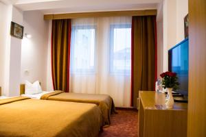 阿拉德Hotel Riga的酒店客房设有两张床和电视。