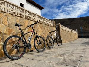 大塔拉哈尔Casa Mararía的两辆自行车停在石墙旁边