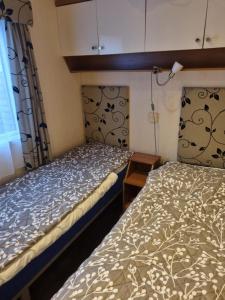 德科赫Chalet Zanderij nr. 16 op Chaletpark Bregkoog的小型客房 - 带2张床和窗户
