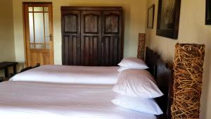 GeelwalWagendrift Lodge的一间卧室配有一张带白色床单的床和木门。