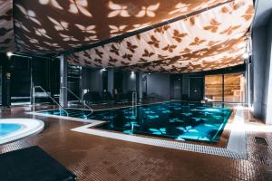 库雷萨雷阿伦斯伯格精品酒店&SPA的一个带天花板的房间的大型游泳池