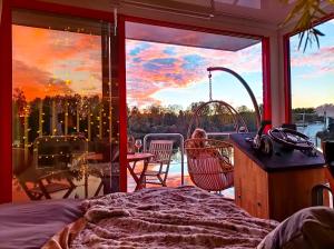 Saint-Martin-la-GarenneEscale Royale Port Ilon的一间卧室,从阳台上可欣赏到日落美景