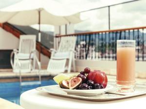 萨尔塔索拉尔德拉广场酒店的桌上的水果和一杯果汁