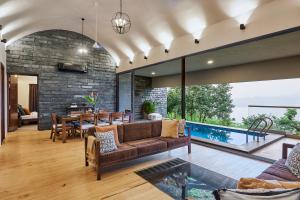 罗纳瓦拉SaffronStays Yahvi Waters by Kosha Villas, Pawna - pool villa with stunning lake view的开放式客厅配有沙发和桌子