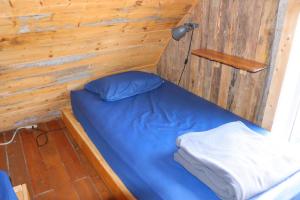 L’Anse-au-Griffon格里芬艳遇木屋旅舍的一间小卧室,配有一张蓝色的木墙床