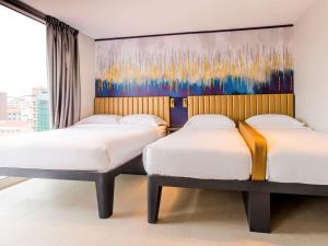 新加坡ibis budget Singapore Gold的墙上画画的房间里设有两张床