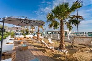 贝拉里亚-伊贾马里纳Miami Suite的海滩上摆放着椅子和遮阳伞,还有棕榈树