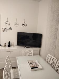 蒙特西尔瓦诺VerdeMare的一间白色的饭厅,配有桌子和电视