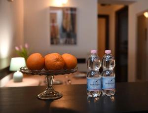 威尼斯Grace Apartment in Venice的桌子上放两瓶水和一碗橙子