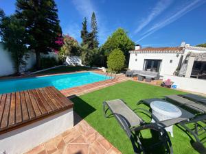 马贝拉Luxury Villa Los Levitos- San Pedro, Marbella的一个带游泳池和房子的后院