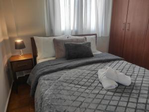 新马尔马拉斯Kashmir Luxury Apartments的一间卧室,床上有两双白鞋