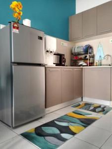 汝来H&H Lovely Homestay in Nilai (Residensi Lili)的厨房配有不锈钢冰箱和色彩缤纷的地毯。