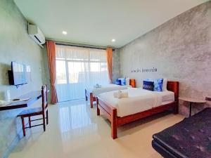 色军Hug Sakhonnakhon Hotel的酒店客房配有两张床和一张书桌