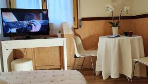 博洛尼亚圣费利切酒店的客厅配有电视和带桌子的桌子。