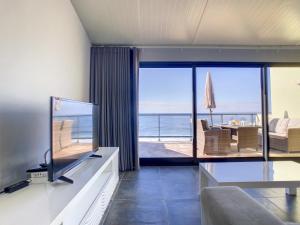 滨海保尔On the Wave by LovelyStay的带电视的客厅,享有海景。