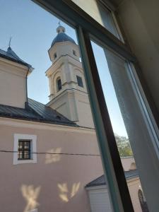 维尔纽斯25 Hours Hostel的从窗口欣赏带钟楼建筑的景色