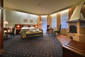 玛丽亚温泉Hotel Morris Relax & Wellness的酒店客房配有一张床和一个壁炉。