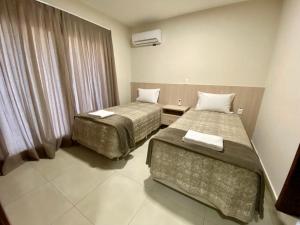 伊瓜苏Residencial Shalfa的酒店客房设有两张床和窗户。