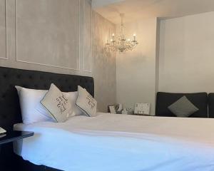 七岩赛姆海滩度假酒店的卧室配有一张带吊灯的大型白色床。