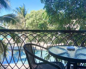 七岩赛姆海滩度假酒店的阳台配有桌椅,享有水景