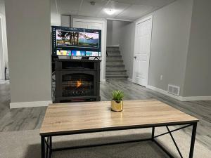 温尼伯Cozy Modern and Lavish 2 Bedroom Basement Suite的客厅配有咖啡桌和壁炉