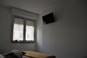 斯培西亚New apartment close to the Cinque Terre的卧室配有一张床,墙上配有电视