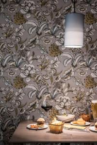 丁克尔斯比尔HOTEL & SPA Goldene Rose的一张桌子,上面放有食物板,墙上贴有壁纸