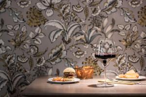 丁克尔斯比尔HOTEL & SPA Goldene Rose的一张桌子,上面放着三明治和一杯葡萄酒