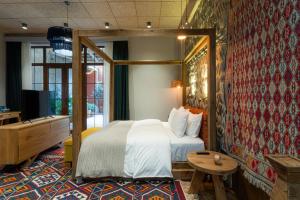 第比利斯Khedi Hotel by Ginza Project的一间卧室配有一张床、一张桌子和一台电视。
