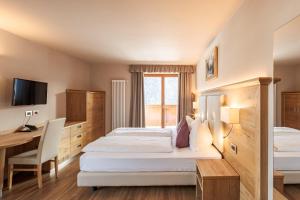 维哥迪法萨Albergo Belvedere的酒店客房配有两张床和一张书桌